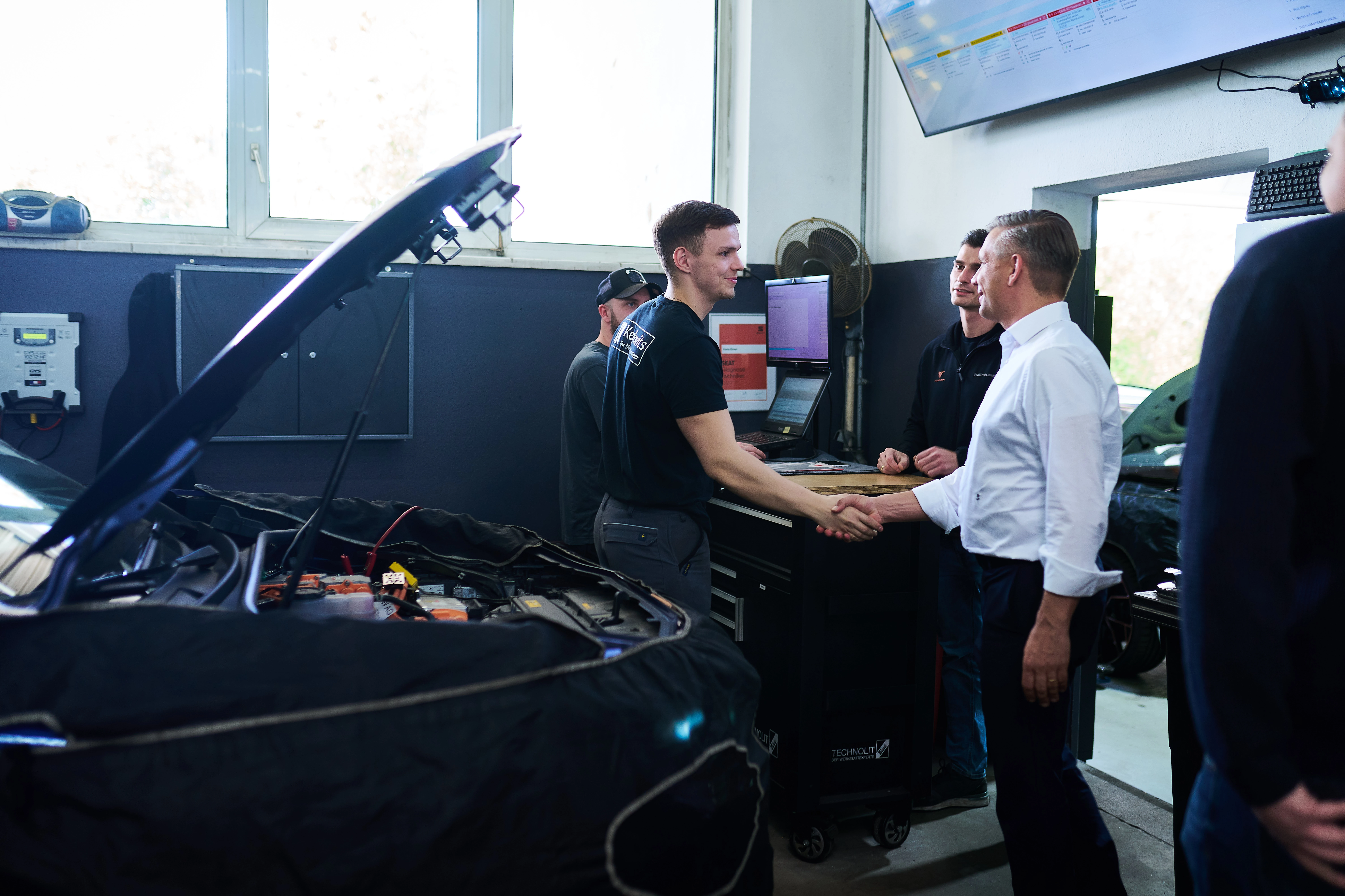 Bundesminister Wolfgang Hattmannsdorfer mit Lehrlingen in einer Werkstatt